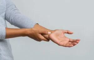 Close up woman holding her wrist, pain from using computer