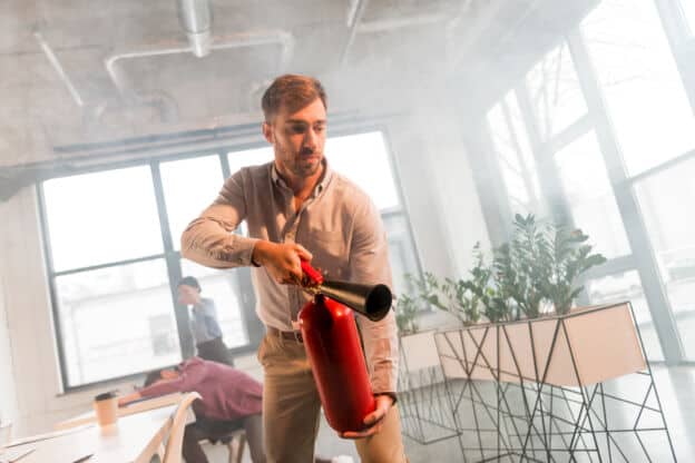 Handsome businessman holding extinguisher in offic 2021 09 03 07 40 16 utc