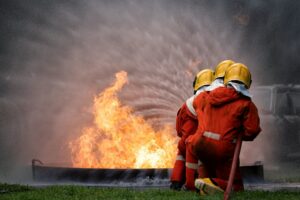 fire fighter team on training with gas and oil fire hold hose spray jet water spray to extinguish